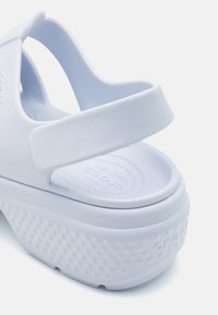 Jasnoniebieska sandałka Crocs na platformie z paskiem z tyłu, teksturowaną podeszwą i wytłoczonym logo na wkładce i pięcie.