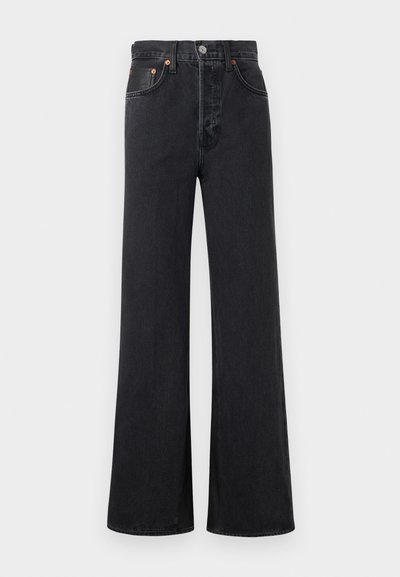 Μαύρα τζιν παντελόνια ψηλόμεσα με φαρδιά μπατζάκια, μπροστινό κουμπί και φερμουάρ, δύο μπροστινές τσέπες και ραφές, παρουσιασμένα σε απλό φόντο.