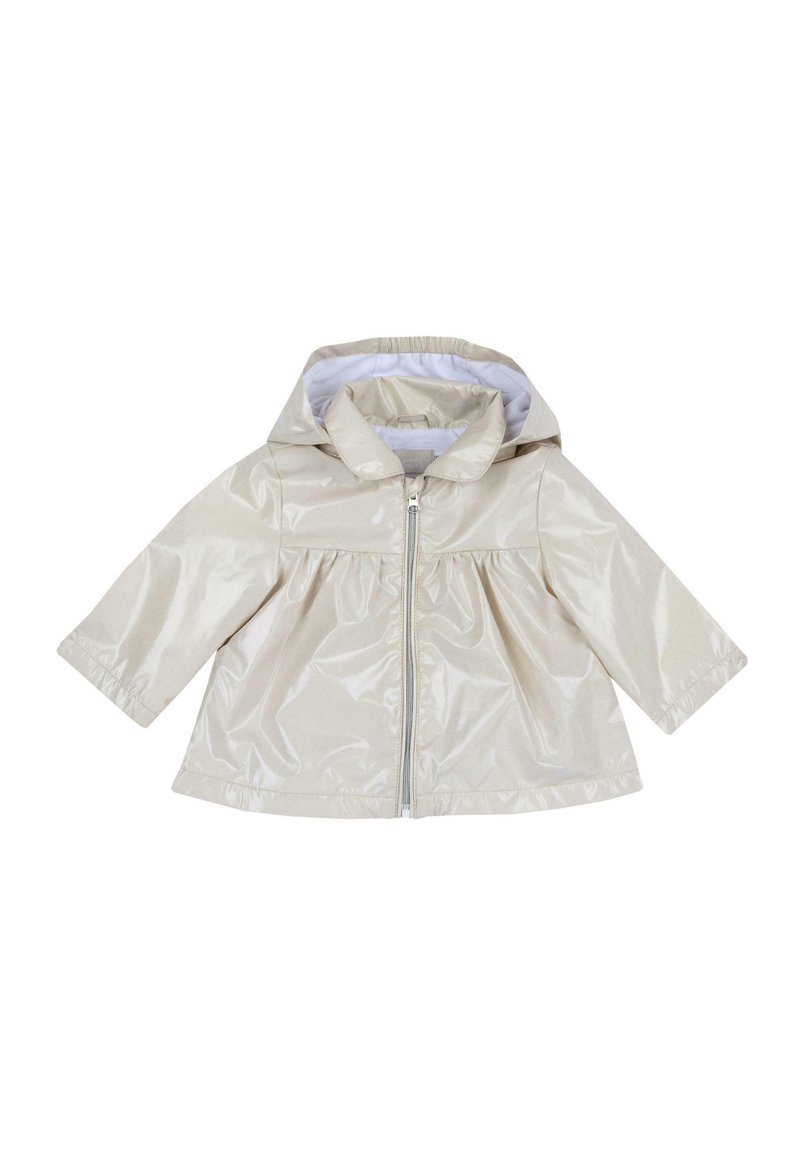 Veste de pluie beige, brillante, avec capuche, fermeture éclair sur le devant et manches longues. Présente une taille froncée et une doublure intérieure blanche.