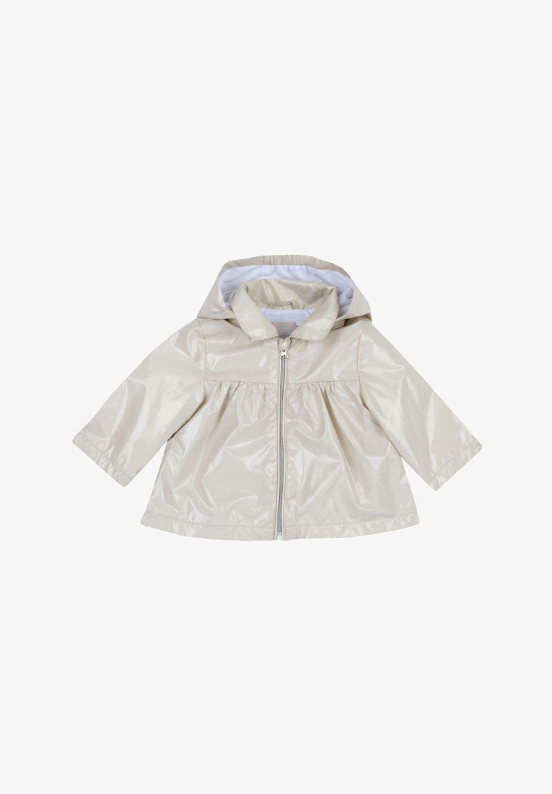 Veste de pluie beige, brillante, avec capuche, fermeture éclair sur le devant et manches longues. Présente une taille froncée et une doublure intérieure blanche.