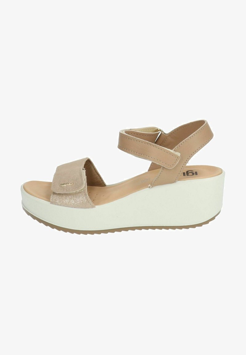 Béžové sandály s texturovaným akcentovaným páskem, nastavitelnými pásky kolem kotníku a bílou klínovou podrážkou s vzorovaným základem pro lepší přilnavost.