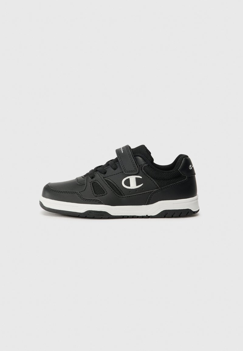 Chaussure de sport noire avec une tige en mesh et en synthétique, accents blancs, sangle ajustable et semelle en caoutchouc pour l'adhérence.