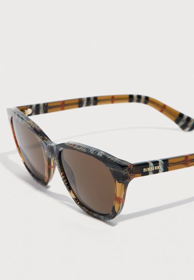 Lunettes de soleil Burberry écaille de tortue avec des verres rectangulaires marron et des branches à motif comportant le logo Burberry sur le côté.