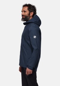 Navy blue waterproof jacket with a hood, featuring a logo on the left sleeve and side pockets, crafted from smooth, durable fabric.