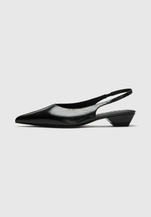 Zapato slingback de cuero negro con punta afilada y tacón bajo de bloque, mostrado en perfil lateral sobre un fondo gris neutro.