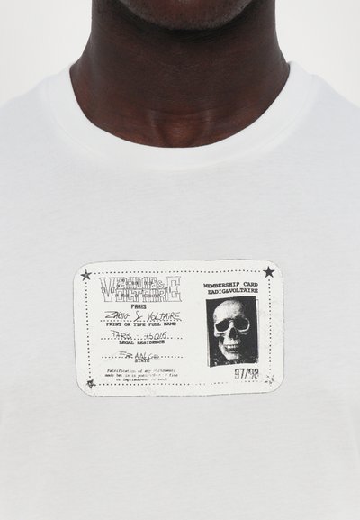 Tricou alb din bumbac, cu un design imprimat de card de membru negru, având un grafic cu un craniu și detalii textuale. Imprimarea texturată adaugă profunzime.