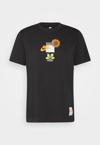 Svart Nike t-shirt med en grafik av en orange solros, gröna blad, jord och Nike-logotypen ovanför bröstet.