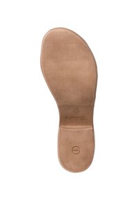Beige gummiskoinnersula med en slät yta och ribbad textur. Formad kontur och präglade varumärkesdetaljer är närvarande.