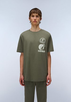 Olivengrøn bomulds t-shirt med korte ærmer, rund hals og trykte grafik på brystet med cirkulære og tekst-elementer.