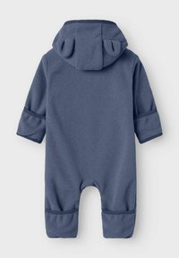 Jumpsuit para bebé de felpa azul marino con capucha que presenta dos pequeñas orejas de tela, mangas largas y piernas de pantalón con puños.