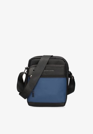 Compacte crossbodytas in zwart en blauw met voorvak met rits, verstelbare band en "pierre cardin" logo op het bovenste voorpaneel.