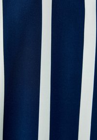 Tessuto a strisce verticali blu navy e bianco, con una texture liscia e una trama fitta, adatto per abbigliamento o decorazioni.