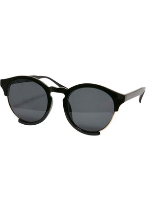 Occhiali da sole neri con lenti rotonde, finitura lucida e bordi distintivi ispirati allo stile cat-eye. Accenti metallici sul bordo delle lenti.