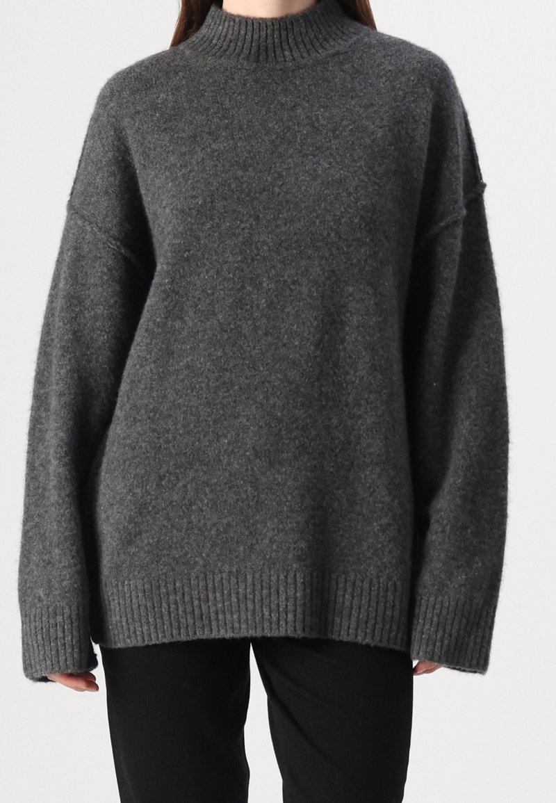 Pull gris foncé oversize avec un col montant côtelé, des épaules tombantes et un bord-côte à l'ourlet ; confectionné dans un tissu doux et texturé.