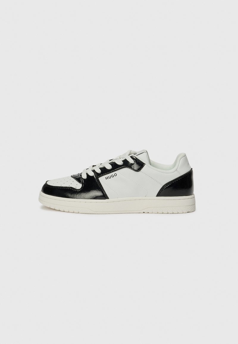 Sneakers sintetiche bianche e nere con accenti lucidi, punta forata, lacci rotondi e suola in gomma testurizzata. Logo sul lato.