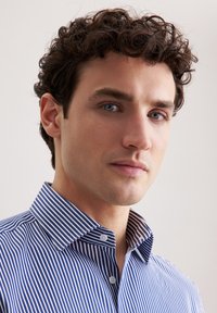 Blauw en wit gestreepte geborduurde shirt met een knoopsluiting aan de voorkant. De stof lijkt glad en lichtgewicht, met een klassiek ontwerp.