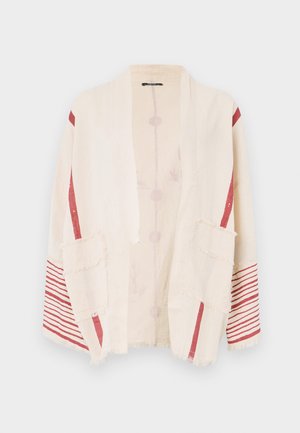 Beige kimono-stiljakke med røde aksentstriper og to lappelommer. Laget av lett stoff med frynsete kanter og subtilt blomstermønster.