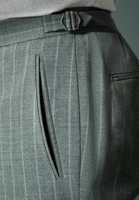 Gray pinstriped trousers with a tailored fit, featuring a side pocket, belt loops, and a silver buckle on a flat waistband.