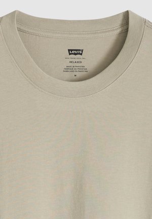 Camiseta Levi's de ajuste relajado en color beige claro con cuello redondo, talla mediana, fabricada en Pakistán, mostrando detalle de costura en el cuello.