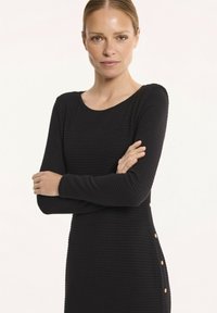 Czarna ribbed sukienka z długimi rękawami, okrągłym dekoltem i dekoracyjnymi guzikami po bokach. Gładka tekstura z dopasowanym krojem.