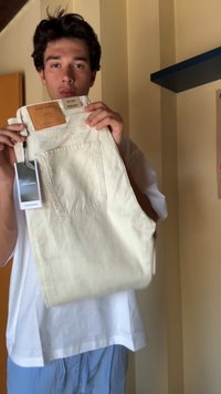 Λευκό τζιν παντελόνι με πίσω τσέπη και ένα καφέ δερμάτινο ετικετάκι στη ζώνη, με κρεμαστό καρτελάκι.