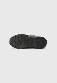 Schwarze Sportschuhsohle mit tiefen Rillen und erhöhten Mustern für Halt, aus Gummi gefertigt, mit einem soliden und langlebigen Design.