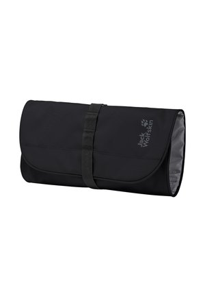 Trousse de toilette noire à enrouler avec sangle à boucle et logo Jack Wolfskin sur le rabat, présentée fermée et vue de côté.