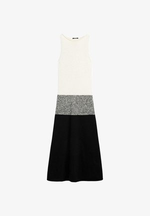 Mouwloze midi-jurk met een aansluitende witte top, een grijze middenpartij met vlekjes en een uitlopende zwarte rok aan de onderkant.