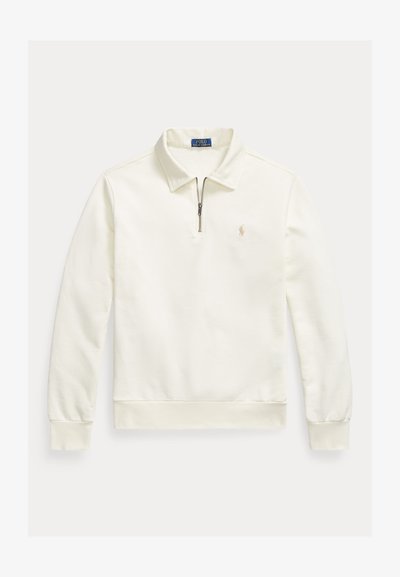 Polo à manches longues de couleur crème avec fermeture éclair d'un quart, col, poignets et ourlet côtelés, et petit logo brodé sur la poitrine gauche.