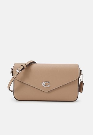 Brun crossbody taske med en tekstureret overflade, sølv hardware og flaplukning. Har et logo-ornament og en justerbar rem.