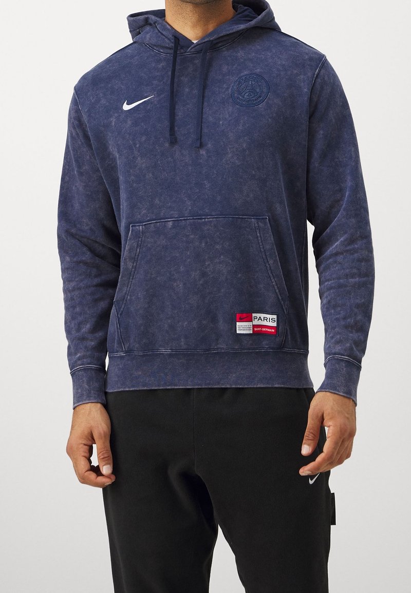 Granatowy hoodie wykonany z bawełny, z kieszenią z przodu, logo Nike, naszywką Paris Saint-Germain oraz teksturowanym, wyblakłym wykończeniem.