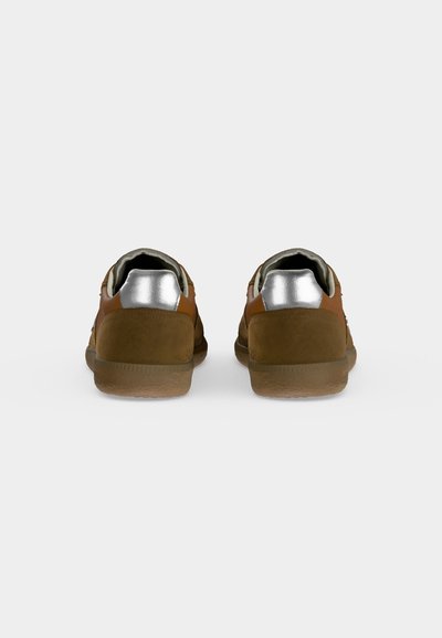 Paire de baskets en daim marron avec languettes argentées au talon vues de dos sur un fond gris clair uni.