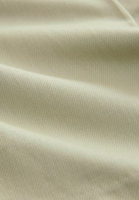 Tissu beige clair avec une texture lisse et un motif en chevrons subtil, mettant en valeur des détails de tissage fins et un éclat minimal.
