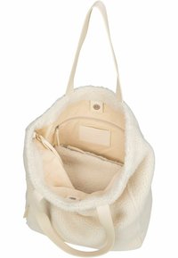 Jasna kremowa torba na ramię o miękkim, teksturowanym wykończeniu. Wewnątrz znajduje się kieszeń na zamek oraz gładka podszewka, a także wytrzymałe ramiączka.