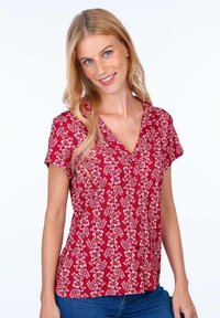 Red floral blouse with short sleeves, v-neckline, and button details. Fabric is lightweight with a smooth texture, featuring a small white flower pattern.