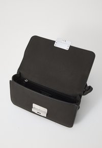 Borsa a tracolla nera in pelle con superficie testurizzata, hardware argentato, chiusura a scatto e tasca interna con zip. La borsa ha un design strutturato.