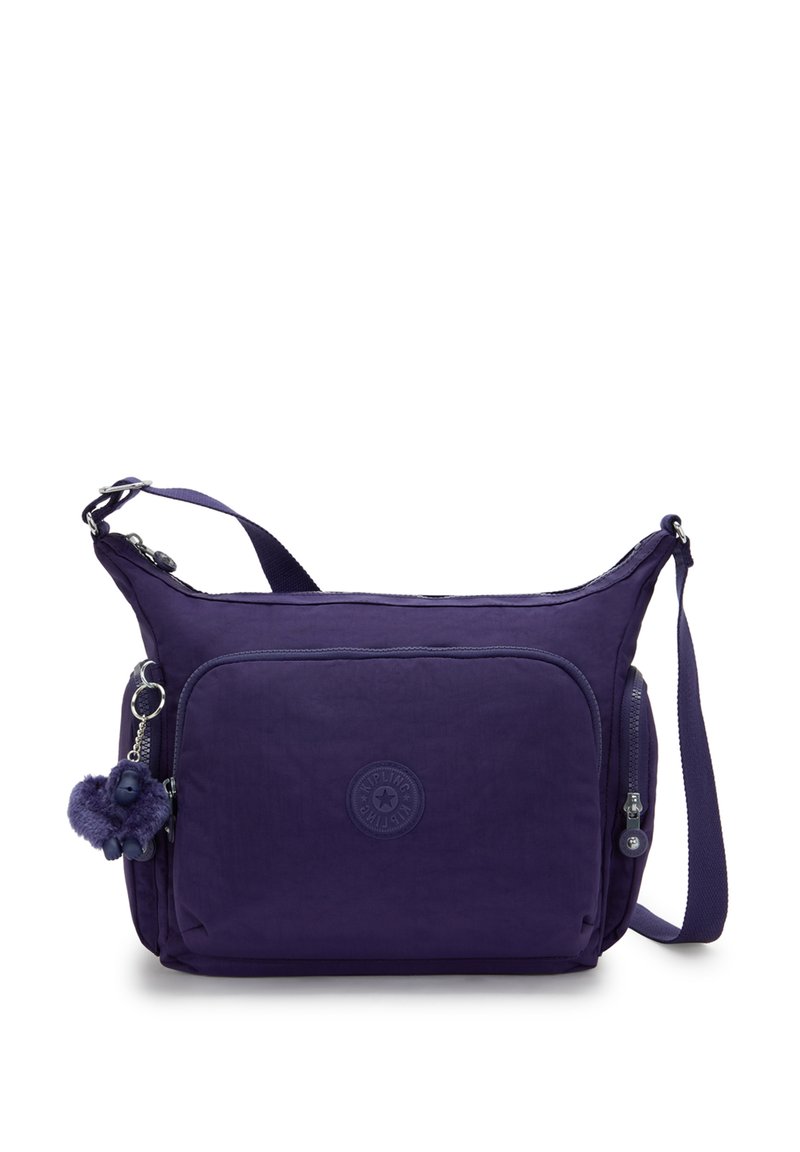 Borsa a spalla in tessuto viola con un compartimento principale con zip, tasca frontale e un charm peloso attaccato. Presenta una tracolla regolabile.