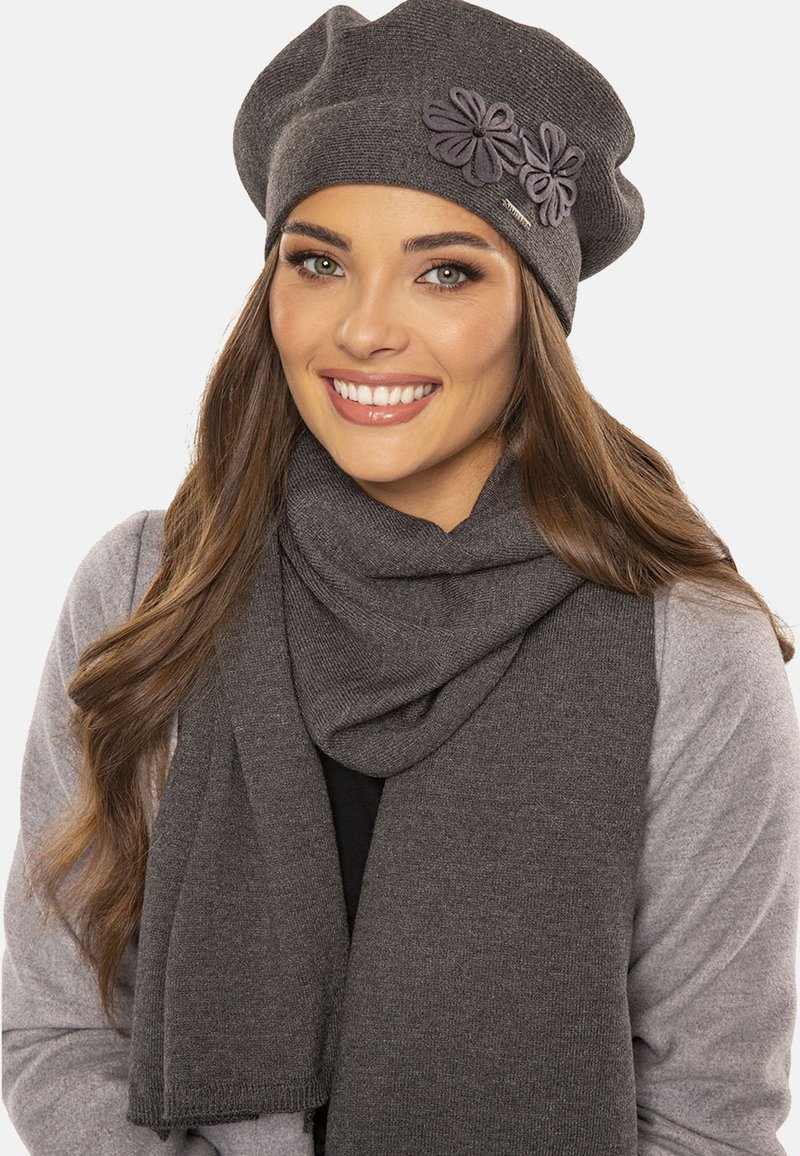 Berretto a maglia grigio con accento floreale e sciarpa coordinata. Tessuto morbido, vestibilità rilassata, design texture; entrambi gli articoli si completano a vicenda.