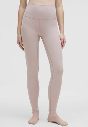 Light pink leggings made of stretchy fabric, high-waisted design with a smooth texture, featuring subtle stitching details along the seams.