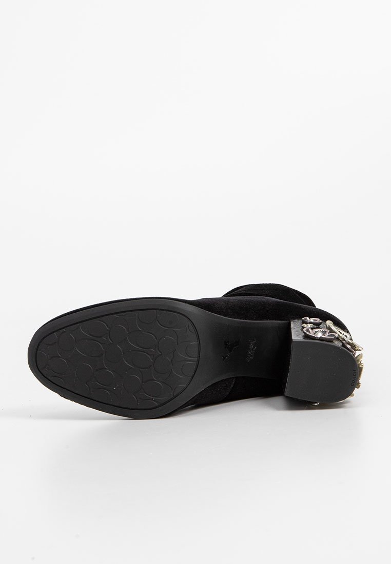 Schwarzer Wildleder-Stiefelette mit einer strukturierten Gummisohle, dekorativer silberner Hardware an der Seite und einem geschlossenen Zehendesign.