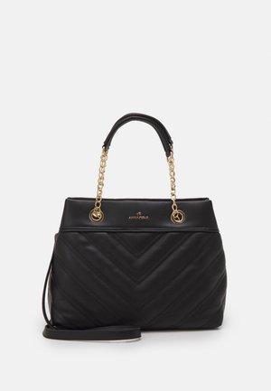 Musta tilkkulaukku kullankeltaisilla ketjukiinnikkeillä ja kahvoilla. Mukana on sileä pinta ja irrotettava olkahihna monipuolisuutta varten.