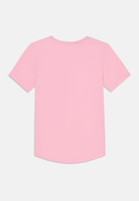T-shirt à manches courtes en coton rose doux, avec un col rond et un ourlet arrondi, présentant une texture lisse sans motifs ni accents.
