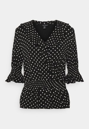 Schwarze Bluse mit weißen Punkten, rüschigem V-Ausschnitt, dreiviertel Puffärmeln und elastischem Taillenbund.