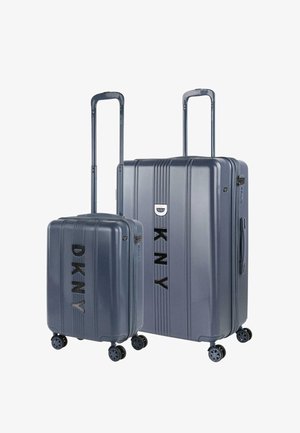 Dos maletas rígidas de color gris oscuro, una grande y una pequeña, cada una con cuatro ruedas, asas retráctiles y el logo negro "DKNY" en la parte frontal.
