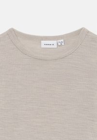 Lysegrå bomull T-skjorte med rund hals, ribbet tekstur og merkedetaljer. Enkelt, minimalistisk design som passer til hverdagsbruk.