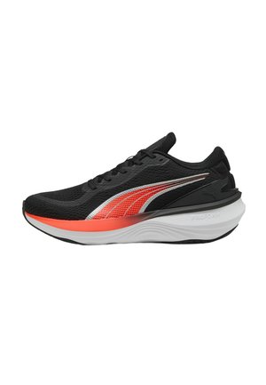 Scarpa da corsa nera con tomaia in rete, accenti rossi e argento, suola bianca imbottita e suola esterna nera texturizzata. Presenta lacci tradizionali.