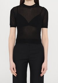 Czarny prążkowany top z krótkim rękawem o przezroczystej fakturze, z okrągłym dekoltem i dopasowanym krojem, z akcentem logo na kołnierzu.