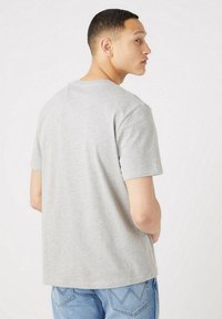 Gray short-sleeve t-shirt made of cotton, featuring a crew neck and relaxed fit. The back shows clean lines with no visible patterns or graphics.