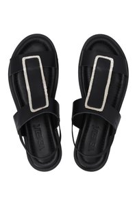 Schwarze Sandalen aus glattem Leder mit zwei breiten Riemen und einem rechteckigen silbernen Akzent an der Oberseite. Offene Zehen.