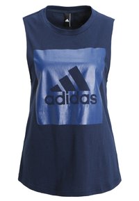 Navy sinäkkäällä muulla puolella puuvillapaita, jossa on suuri kiiltävä sininen neliö mustalla adidas-logolla keskellä. Sileä rakenne, rento istuvuus.